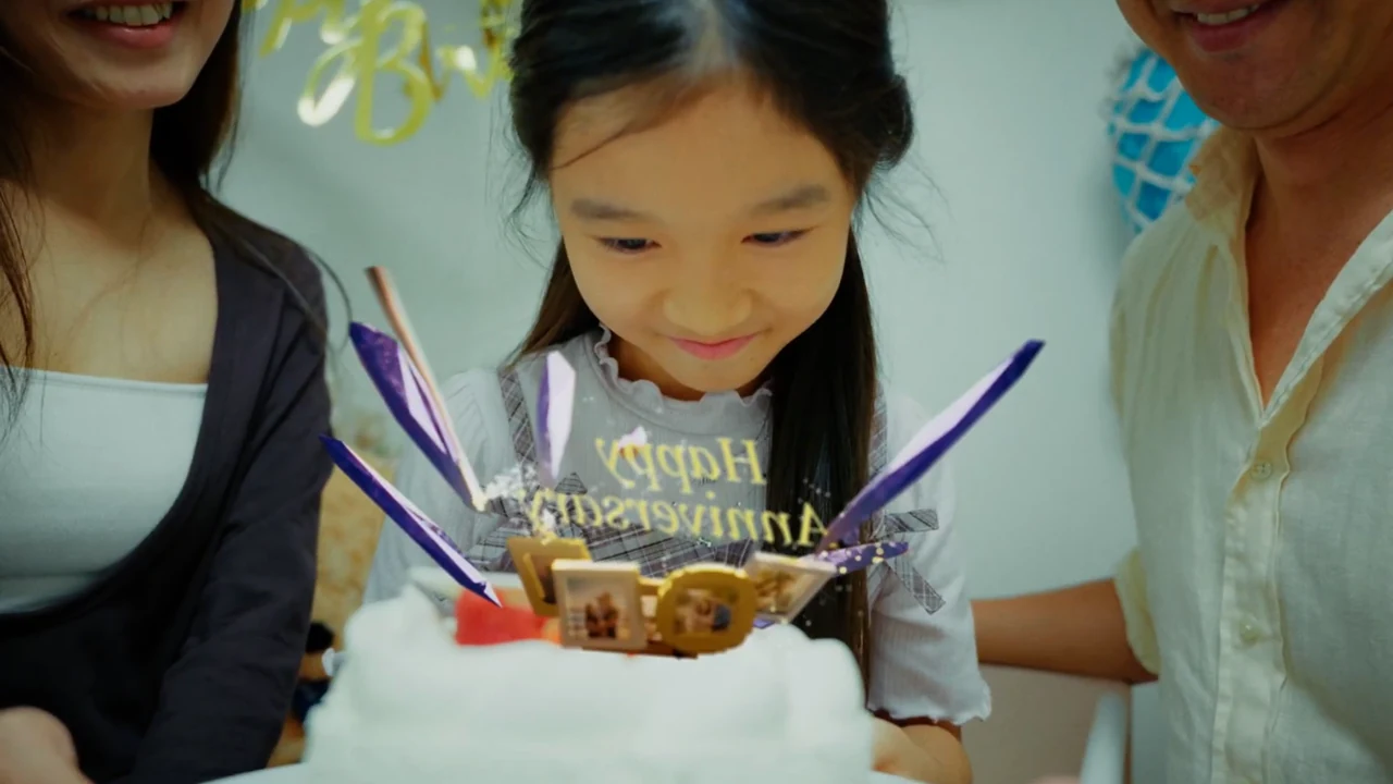 誕生日の女の子とケーキを見守る家族